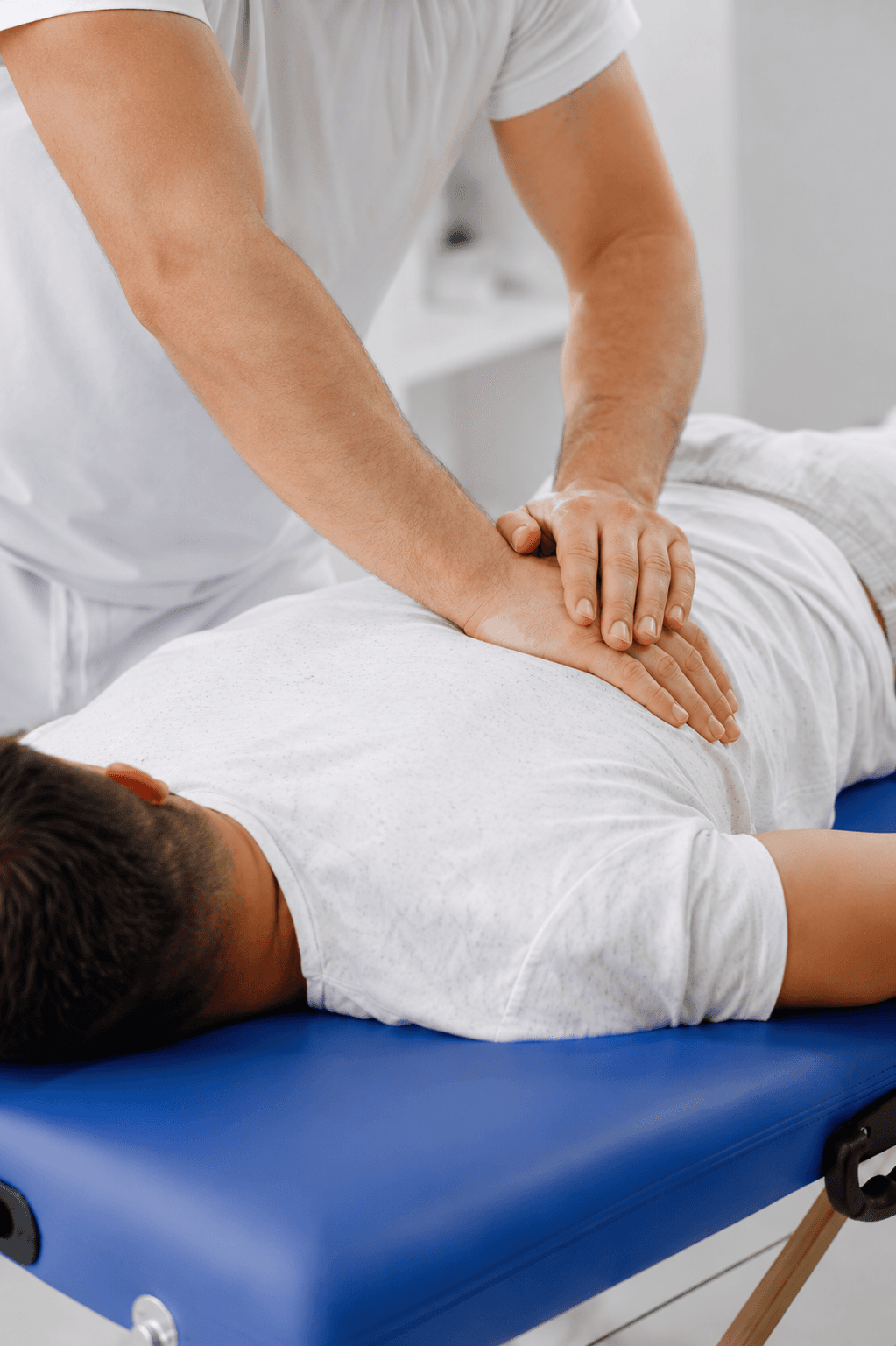 Chiropractor adjusting a patient in a treatment room